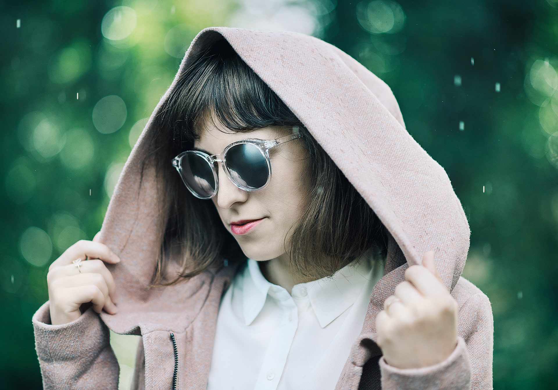 A female model wearing a pair of sunglasses in the rain