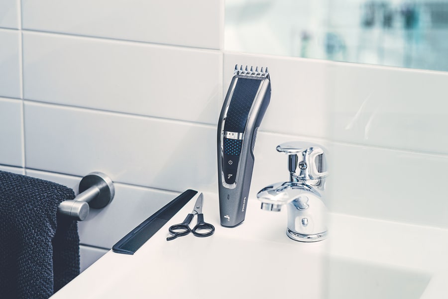 Mood product photography taken in the bathroom. The Philips trimmer and it's accessories: hair comb and short scissor are perfectly placed on the side of the sink. A photograph taken with a commercial purpose in mind, but for a concept project.